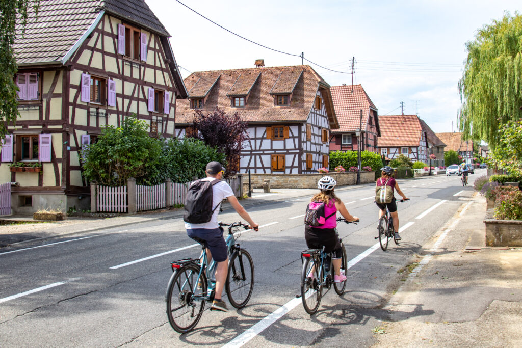 Cyclistes traversant un village alsacien