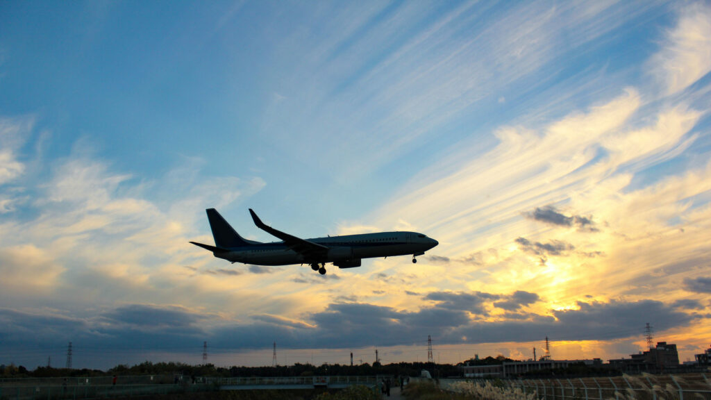 Avion qui atterrit sur fond de soleil levant